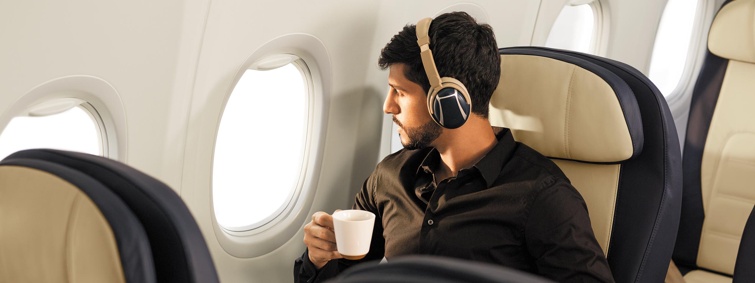 Passenger with headphones and coffee